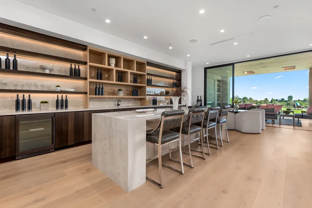 25079 Jim Bridger Road Home in Calabasas, California. Discover the epitome of refined luxury in this stunning new estate on a beautiful 1.6-acre lot in Hidden Hills. The open floor plan features a chef's kitchen, butler's pantry, and expansive great room with sliding walls of glass. Enjoy amenities like a home theater, large game room, and an oversized gym & spa.