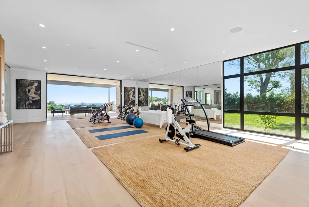 25079 Jim Bridger Road Home in Calabasas, California. Discover the epitome of refined luxury in this stunning new estate on a beautiful 1.6-acre lot in Hidden Hills. The open floor plan features a chef's kitchen, butler's pantry, and expansive great room with sliding walls of glass. Enjoy amenities like a home theater, large game room, and an oversized gym & spa.