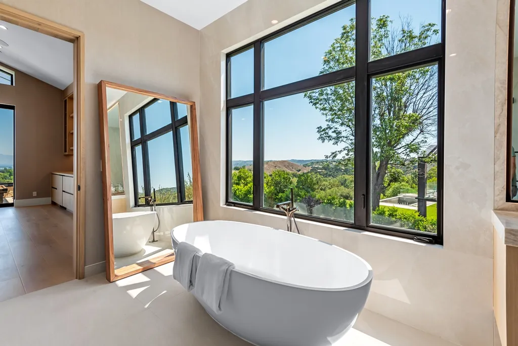 25079 Jim Bridger Road Home in Calabasas, California. Discover the epitome of refined luxury in this stunning new estate on a beautiful 1.6-acre lot in Hidden Hills. The open floor plan features a chef's kitchen, butler's pantry, and expansive great room with sliding walls of glass. Enjoy amenities like a home theater, large game room, and an oversized gym & spa.