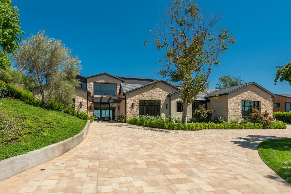25079 Jim Bridger Road Home in Calabasas, California. Discover the epitome of refined luxury in this stunning new estate on a beautiful 1.6-acre lot in Hidden Hills. The open floor plan features a chef's kitchen, butler's pantry, and expansive great room with sliding walls of glass. Enjoy amenities like a home theater, large game room, and an oversized gym & spa.