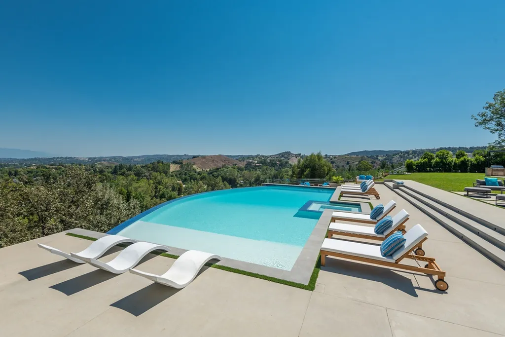 25079 Jim Bridger Road Home in Calabasas, California. Discover the epitome of refined luxury in this stunning new estate on a beautiful 1.6-acre lot in Hidden Hills. The open floor plan features a chef's kitchen, butler's pantry, and expansive great room with sliding walls of glass. Enjoy amenities like a home theater, large game room, and an oversized gym & spa.