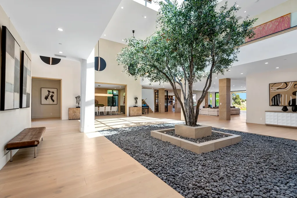 25079 Jim Bridger Road Home in Calabasas, California. Discover the epitome of refined luxury in this stunning new estate on a beautiful 1.6-acre lot in Hidden Hills. The open floor plan features a chef's kitchen, butler's pantry, and expansive great room with sliding walls of glass. Enjoy amenities like a home theater, large game room, and an oversized gym & spa.