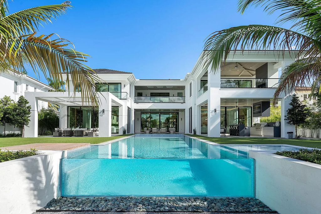 Indulge in the epitome of waterfront luxury at this 10,784-square-foot estate in Royal Palm Yacht & Country Club. Crafted by Wietsma Lippolis Construction, this masterpiece boasts six bedroom suites, expansive living areas curated by Artisan Interiors, and cutting-edge Crestron home technology.
