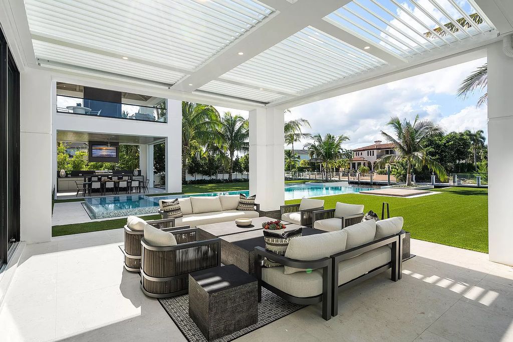 Indulge in the epitome of waterfront luxury at this 10,784-square-foot estate in Royal Palm Yacht & Country Club. Crafted by Wietsma Lippolis Construction, this masterpiece boasts six bedroom suites, expansive living areas curated by Artisan Interiors, and cutting-edge Crestron home technology.