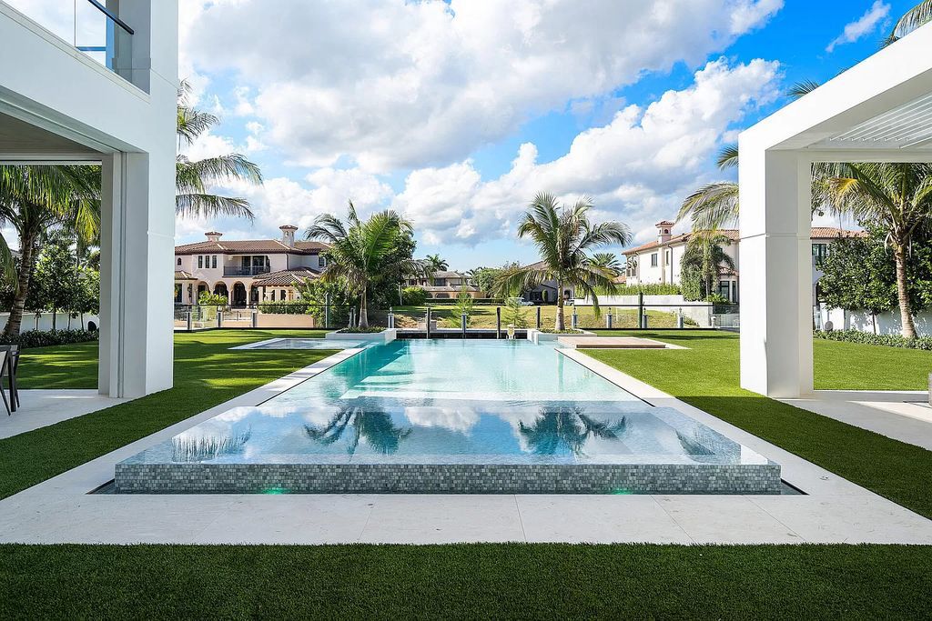 Indulge in the epitome of waterfront luxury at this 10,784-square-foot estate in Royal Palm Yacht & Country Club. Crafted by Wietsma Lippolis Construction, this masterpiece boasts six bedroom suites, expansive living areas curated by Artisan Interiors, and cutting-edge Crestron home technology.
