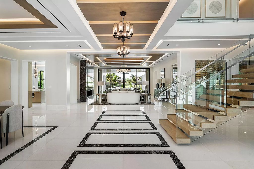 Indulge in the epitome of waterfront luxury at this 10,784-square-foot estate in Royal Palm Yacht & Country Club. Crafted by Wietsma Lippolis Construction, this masterpiece boasts six bedroom suites, expansive living areas curated by Artisan Interiors, and cutting-edge Crestron home technology.