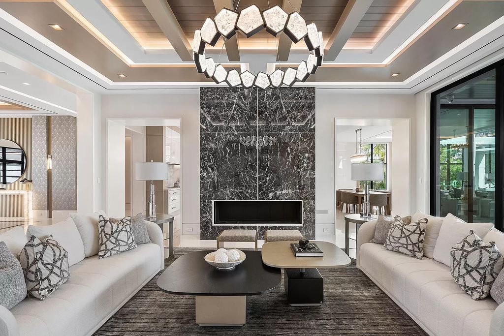 Indulge in the epitome of waterfront luxury at this 10,784-square-foot estate in Royal Palm Yacht & Country Club. Crafted by Wietsma Lippolis Construction, this masterpiece boasts six bedroom suites, expansive living areas curated by Artisan Interiors, and cutting-edge Crestron home technology.