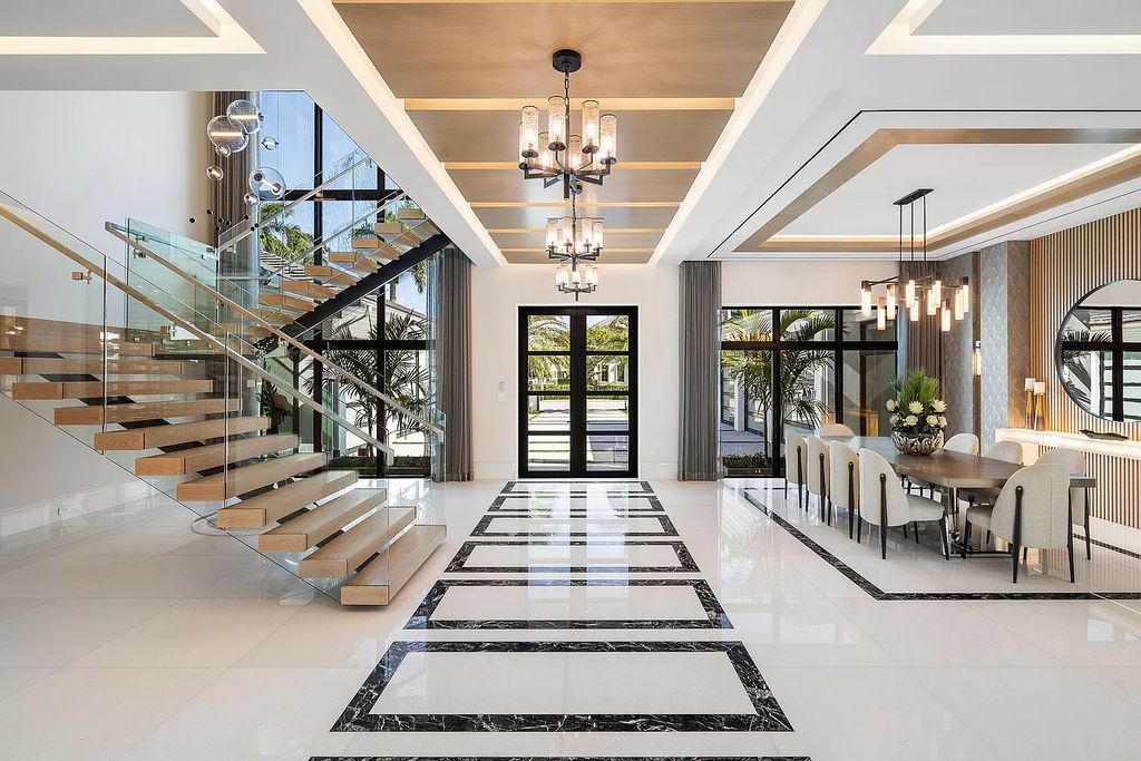 Indulge in the epitome of waterfront luxury at this 10,784-square-foot estate in Royal Palm Yacht & Country Club. Crafted by Wietsma Lippolis Construction, this masterpiece boasts six bedroom suites, expansive living areas curated by Artisan Interiors, and cutting-edge Crestron home technology.