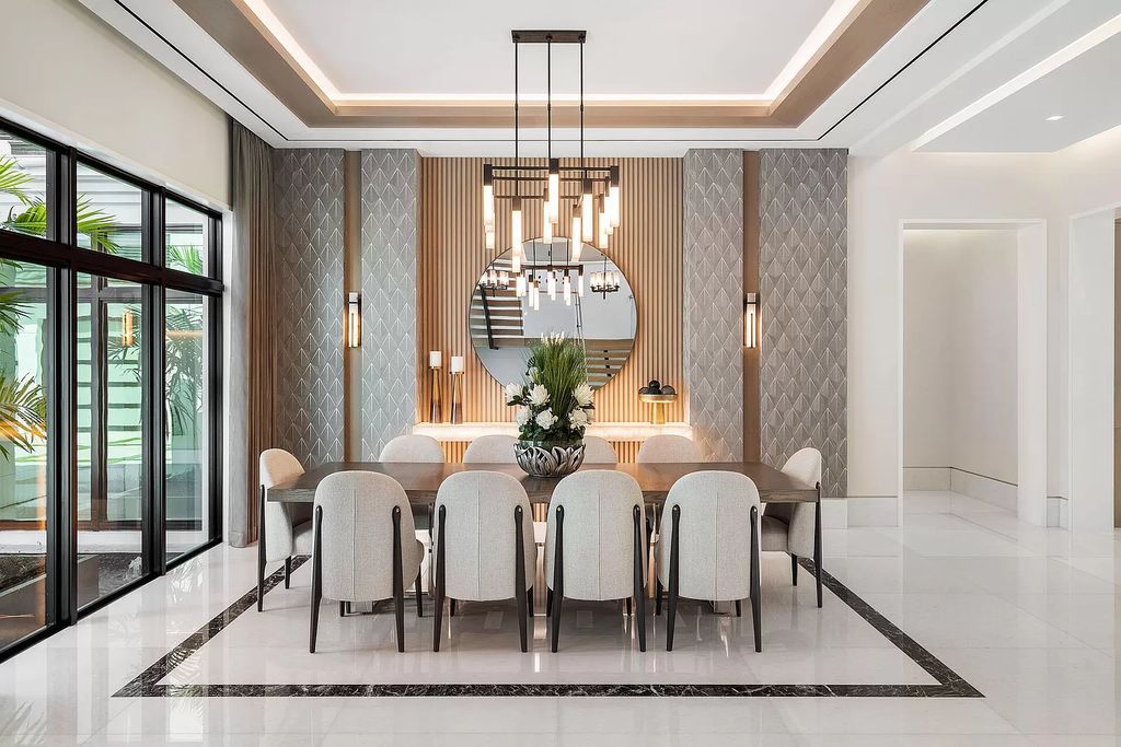 Indulge in the epitome of waterfront luxury at this 10,784-square-foot estate in Royal Palm Yacht & Country Club. Crafted by Wietsma Lippolis Construction, this masterpiece boasts six bedroom suites, expansive living areas curated by Artisan Interiors, and cutting-edge Crestron home technology.