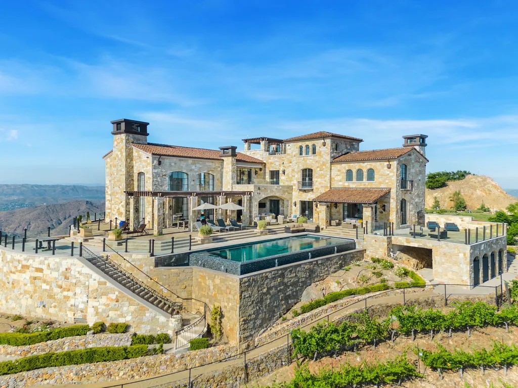340 North Kanan Dume Road Home in Malibu, California. Perched atop a Malibu Canyon peak, the majestic Malibu Rocky Oaks is a stone-clad Tuscan villa offering unrivaled luxury and panoramic views. This 9,000-square-foot estate boasts 37 picturesque acres, a renowned vineyard, and endless world-class amenities. With a private helipad and infinity pool, this masterpiece redefines the essence of luxury living in the Malibu hills.