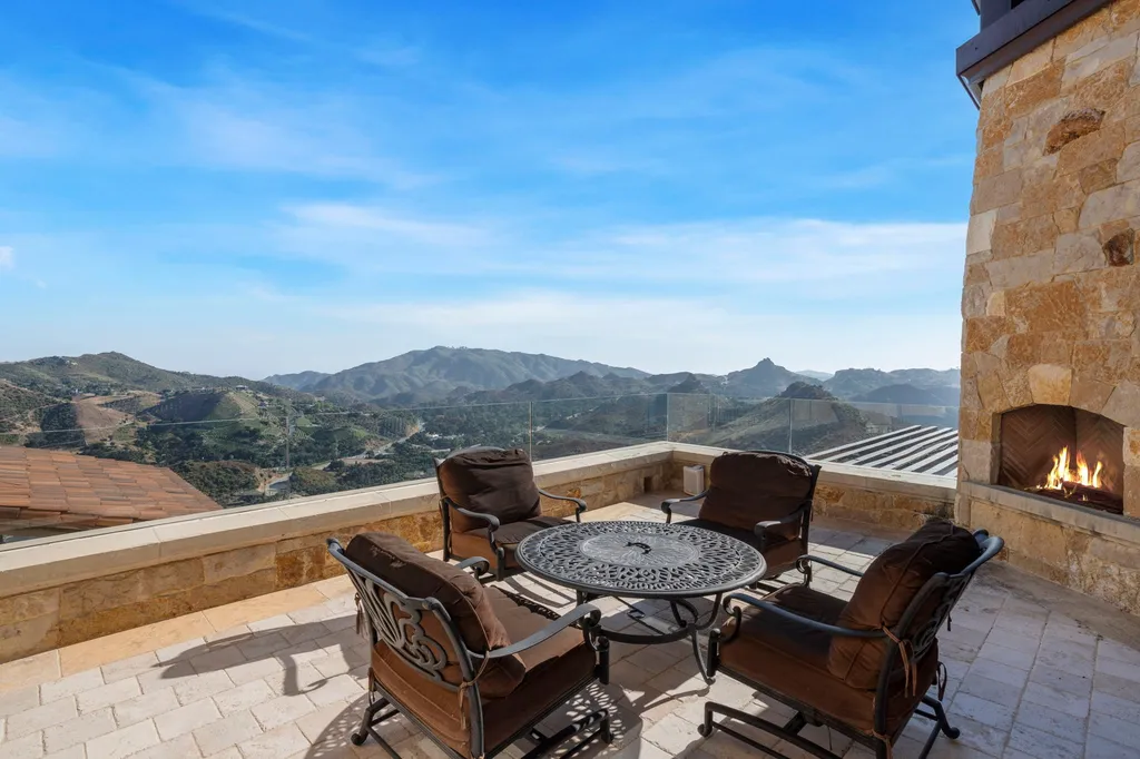 340 North Kanan Dume Road Home in Malibu, California. Perched atop a Malibu Canyon peak, the majestic Malibu Rocky Oaks is a stone-clad Tuscan villa offering unrivaled luxury and panoramic views. This 9,000-square-foot estate boasts 37 picturesque acres, a renowned vineyard, and endless world-class amenities. With a private helipad and infinity pool, this masterpiece redefines the essence of luxury living in the Malibu hills.