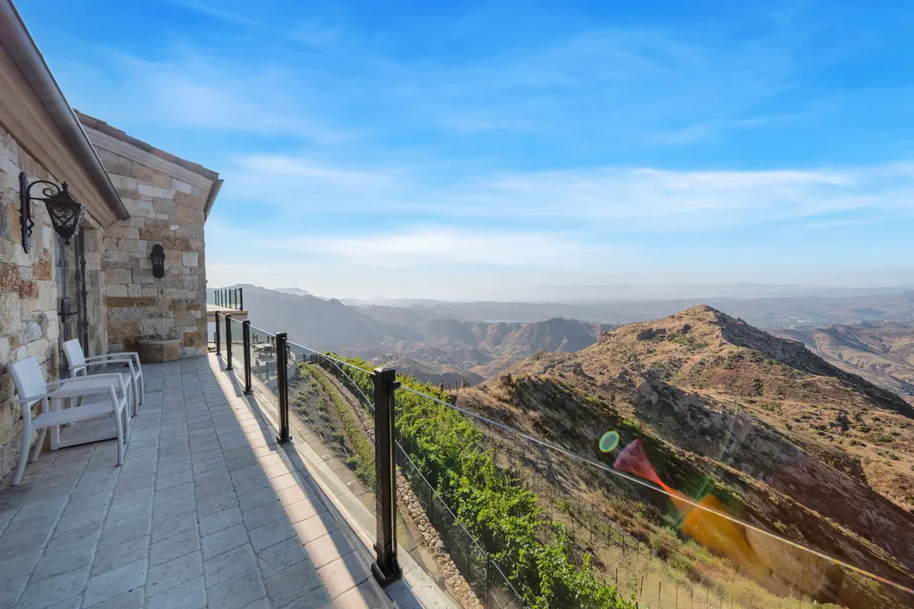 340 North Kanan Dume Road Home in Malibu, California. Perched atop a Malibu Canyon peak, the majestic Malibu Rocky Oaks is a stone-clad Tuscan villa offering unrivaled luxury and panoramic views. This 9,000-square-foot estate boasts 37 picturesque acres, a renowned vineyard, and endless world-class amenities. With a private helipad and infinity pool, this masterpiece redefines the essence of luxury living in the Malibu hills.