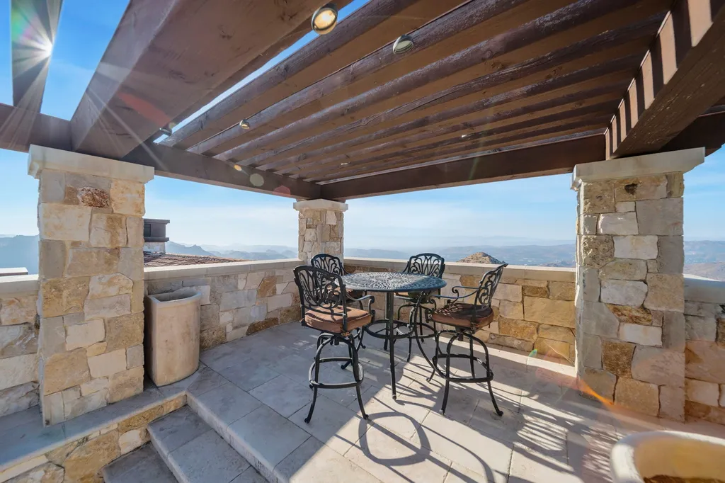 340 North Kanan Dume Road Home in Malibu, California. Perched atop a Malibu Canyon peak, the majestic Malibu Rocky Oaks is a stone-clad Tuscan villa offering unrivaled luxury and panoramic views. This 9,000-square-foot estate boasts 37 picturesque acres, a renowned vineyard, and endless world-class amenities. With a private helipad and infinity pool, this masterpiece redefines the essence of luxury living in the Malibu hills.