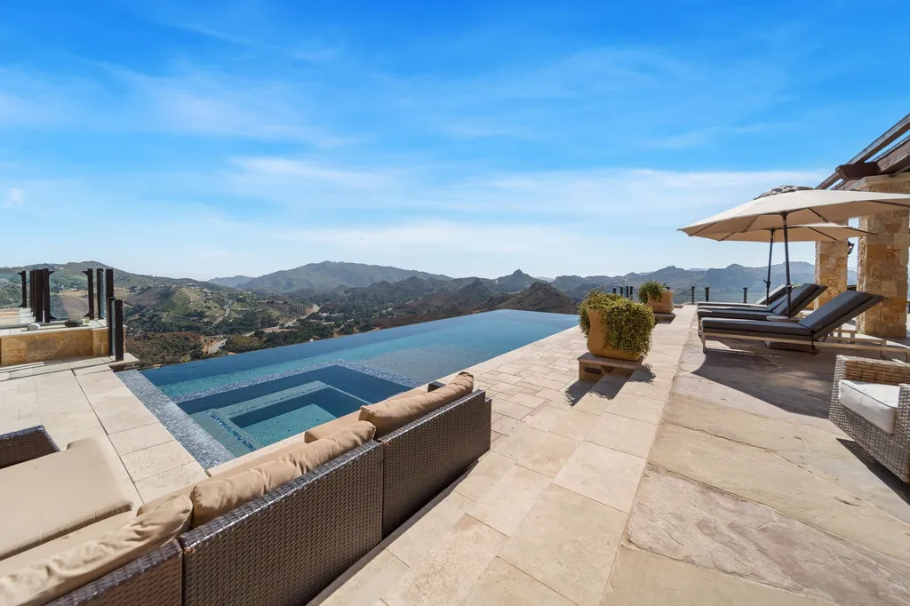 340 North Kanan Dume Road Home in Malibu, California. Perched atop a Malibu Canyon peak, the majestic Malibu Rocky Oaks is a stone-clad Tuscan villa offering unrivaled luxury and panoramic views. This 9,000-square-foot estate boasts 37 picturesque acres, a renowned vineyard, and endless world-class amenities. With a private helipad and infinity pool, this masterpiece redefines the essence of luxury living in the Malibu hills.