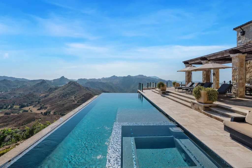 340 North Kanan Dume Road Home in Malibu, California. Perched atop a Malibu Canyon peak, the majestic Malibu Rocky Oaks is a stone-clad Tuscan villa offering unrivaled luxury and panoramic views. This 9,000-square-foot estate boasts 37 picturesque acres, a renowned vineyard, and endless world-class amenities. With a private helipad and infinity pool, this masterpiece redefines the essence of luxury living in the Malibu hills.