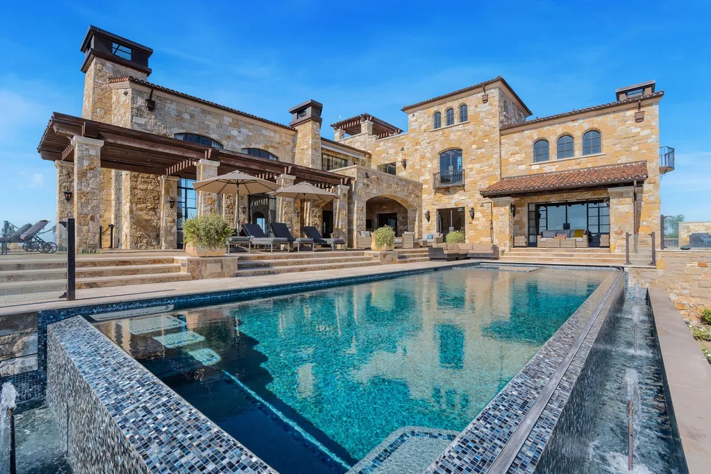 340 North Kanan Dume Road Home in Malibu, California. Perched atop a Malibu Canyon peak, the majestic Malibu Rocky Oaks is a stone-clad Tuscan villa offering unrivaled luxury and panoramic views. This 9,000-square-foot estate boasts 37 picturesque acres, a renowned vineyard, and endless world-class amenities. With a private helipad and infinity pool, this masterpiece redefines the essence of luxury living in the Malibu hills.