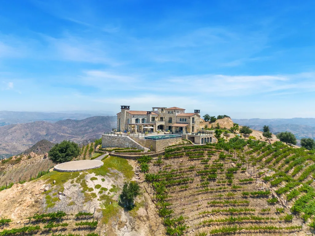 340 North Kanan Dume Road Home in Malibu, California. Perched atop a Malibu Canyon peak, the majestic Malibu Rocky Oaks is a stone-clad Tuscan villa offering unrivaled luxury and panoramic views. This 9,000-square-foot estate boasts 37 picturesque acres, a renowned vineyard, and endless world-class amenities. With a private helipad and infinity pool, this masterpiece redefines the essence of luxury living in the Malibu hills.