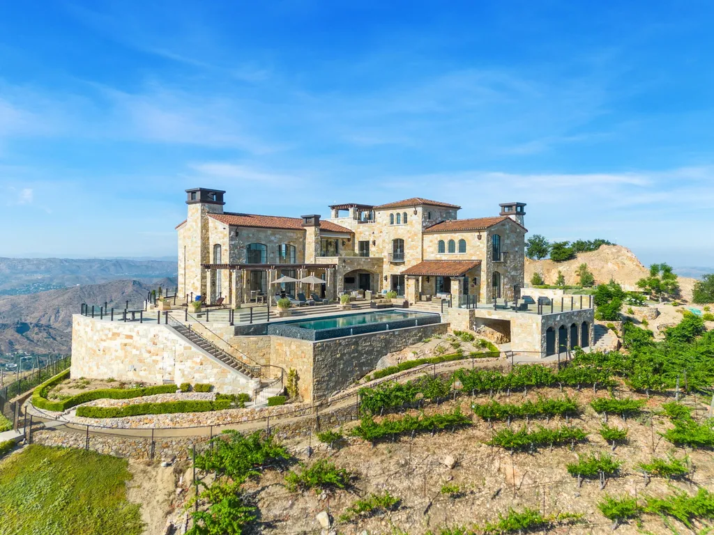 340 North Kanan Dume Road Home in Malibu, California. Perched atop a Malibu Canyon peak, the majestic Malibu Rocky Oaks is a stone-clad Tuscan villa offering unrivaled luxury and panoramic views. This 9,000-square-foot estate boasts 37 picturesque acres, a renowned vineyard, and endless world-class amenities. With a private helipad and infinity pool, this masterpiece redefines the essence of luxury living in the Malibu hills.