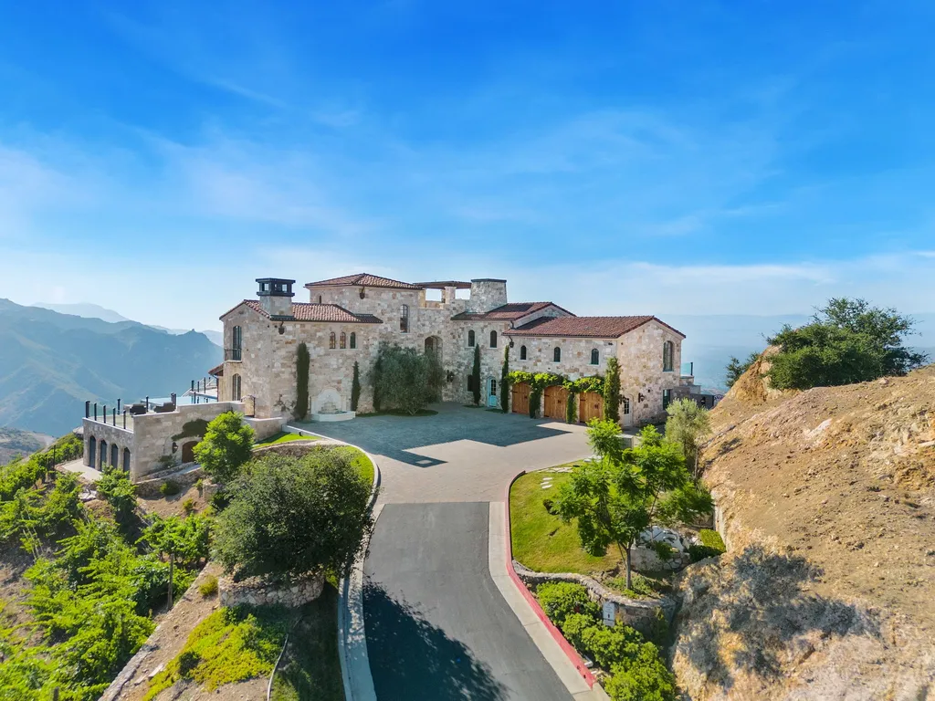340 North Kanan Dume Road Home in Malibu, California. Perched atop a Malibu Canyon peak, the majestic Malibu Rocky Oaks is a stone-clad Tuscan villa offering unrivaled luxury and panoramic views. This 9,000-square-foot estate boasts 37 picturesque acres, a renowned vineyard, and endless world-class amenities. With a private helipad and infinity pool, this masterpiece redefines the essence of luxury living in the Malibu hills.