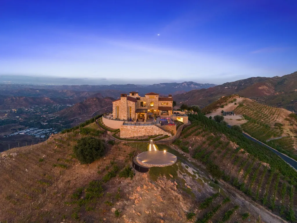 340 North Kanan Dume Road Home in Malibu, California. Perched atop a Malibu Canyon peak, the majestic Malibu Rocky Oaks is a stone-clad Tuscan villa offering unrivaled luxury and panoramic views. This 9,000-square-foot estate boasts 37 picturesque acres, a renowned vineyard, and endless world-class amenities. With a private helipad and infinity pool, this masterpiece redefines the essence of luxury living in the Malibu hills.