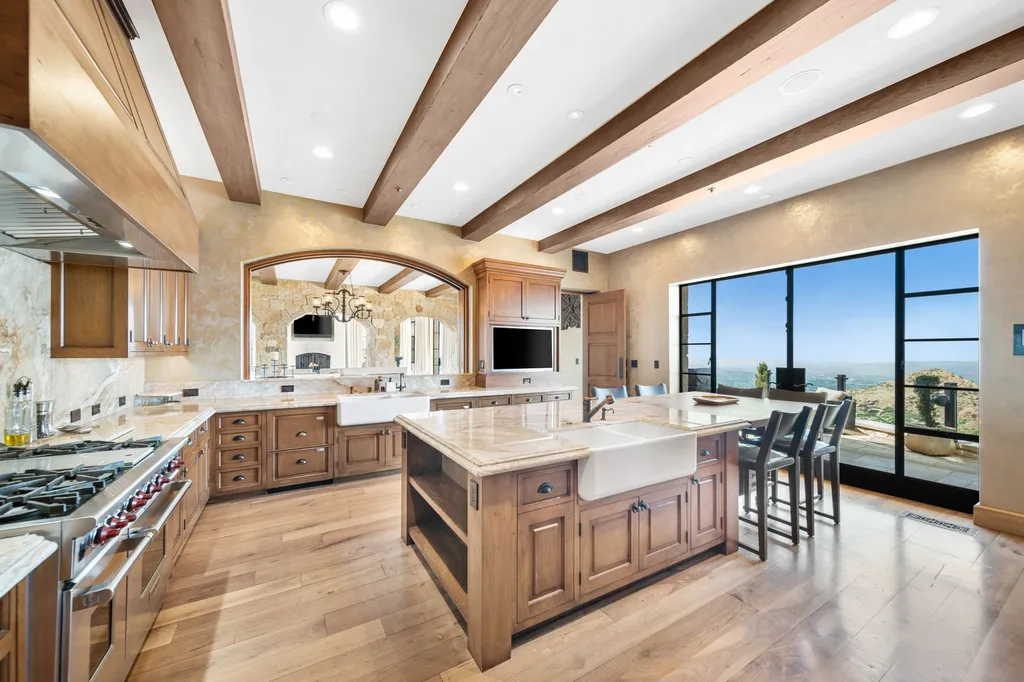 340 North Kanan Dume Road Home in Malibu, California. Perched atop a Malibu Canyon peak, the majestic Malibu Rocky Oaks is a stone-clad Tuscan villa offering unrivaled luxury and panoramic views. This 9,000-square-foot estate boasts 37 picturesque acres, a renowned vineyard, and endless world-class amenities. With a private helipad and infinity pool, this masterpiece redefines the essence of luxury living in the Malibu hills.