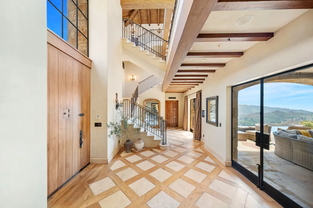 340 North Kanan Dume Road Home in Malibu, California. Perched atop a Malibu Canyon peak, the majestic Malibu Rocky Oaks is a stone-clad Tuscan villa offering unrivaled luxury and panoramic views. This 9,000-square-foot estate boasts 37 picturesque acres, a renowned vineyard, and endless world-class amenities. With a private helipad and infinity pool, this masterpiece redefines the essence of luxury living in the Malibu hills.