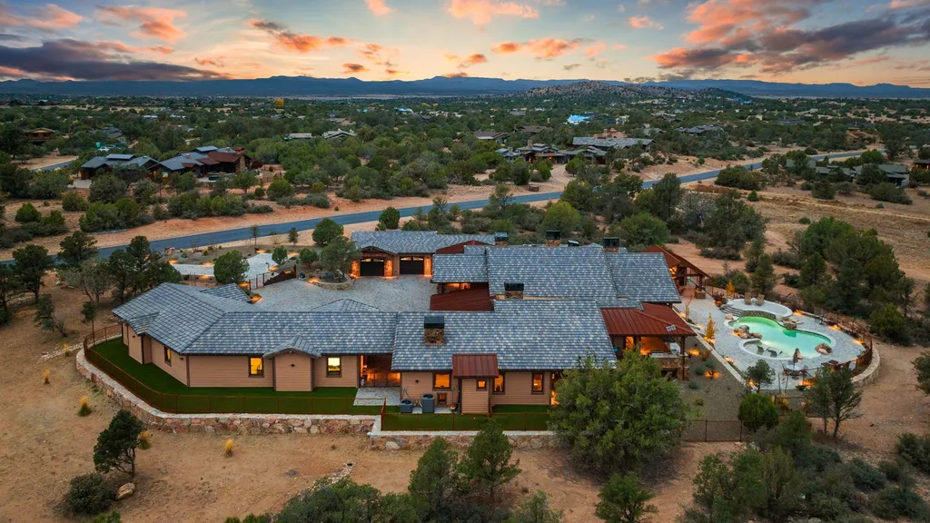 4971 West Three Forks Road Home in Prescott, Arizona. Explore the epitome of luxury living in this privately gated ranch compound with unobstructed views. This 4-bedroom, 5,555 sq.ft home features a 7-car garage, attached guest quarters, private pool with cabana, wet bar, and a 20 ft indoor-outdoor panoramic glass wall door.