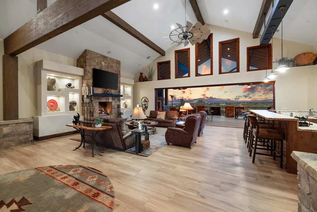4971 West Three Forks Road Home in Prescott, Arizona. Explore the epitome of luxury living in this privately gated ranch compound with unobstructed views. This 4-bedroom, 5,555 sq.ft home features a 7-car garage, attached guest quarters, private pool with cabana, wet bar, and a 20 ft indoor-outdoor panoramic glass wall door.
