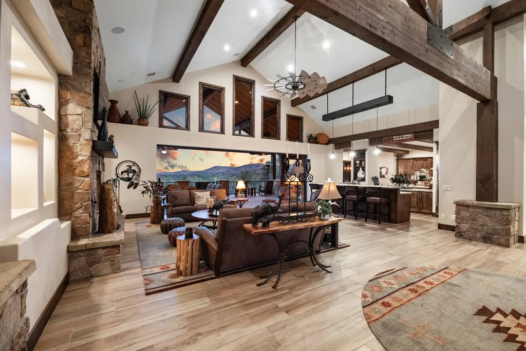 4971 West Three Forks Road Home in Prescott, Arizona. Explore the epitome of luxury living in this privately gated ranch compound with unobstructed views. This 4-bedroom, 5,555 sq.ft home features a 7-car garage, attached guest quarters, private pool with cabana, wet bar, and a 20 ft indoor-outdoor panoramic glass wall door.