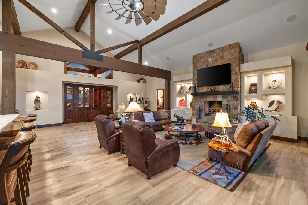 4971 West Three Forks Road Home in Prescott, Arizona. Explore the epitome of luxury living in this privately gated ranch compound with unobstructed views. This 4-bedroom, 5,555 sq.ft home features a 7-car garage, attached guest quarters, private pool with cabana, wet bar, and a 20 ft indoor-outdoor panoramic glass wall door.