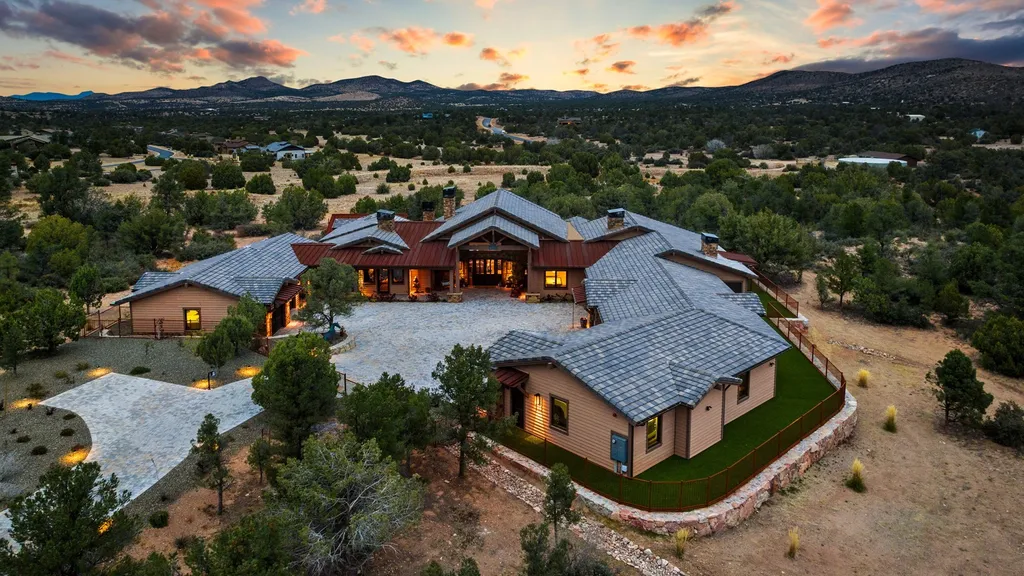4971 West Three Forks Road Home in Prescott, Arizona. Explore the epitome of luxury living in this privately gated ranch compound with unobstructed views. This 4-bedroom, 5,555 sq.ft home features a 7-car garage, attached guest quarters, private pool with cabana, wet bar, and a 20 ft indoor-outdoor panoramic glass wall door.