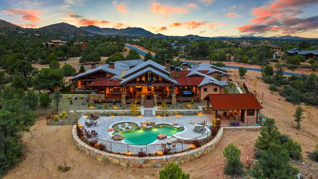 4971 West Three Forks Road Home in Prescott, Arizona. Explore the epitome of luxury living in this privately gated ranch compound with unobstructed views. This 4-bedroom, 5,555 sq.ft home features a 7-car garage, attached guest quarters, private pool with cabana, wet bar, and a 20 ft indoor-outdoor panoramic glass wall door.
