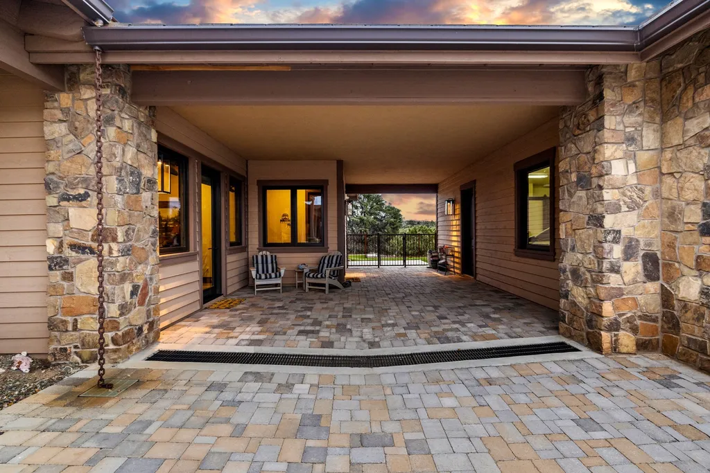 4971 West Three Forks Road Home in Prescott, Arizona. Explore the epitome of luxury living in this privately gated ranch compound with unobstructed views. This 4-bedroom, 5,555 sq.ft home features a 7-car garage, attached guest quarters, private pool with cabana, wet bar, and a 20 ft indoor-outdoor panoramic glass wall door.