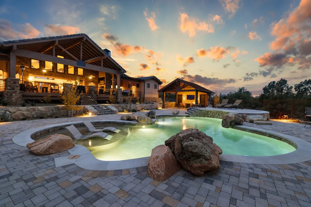 4971 West Three Forks Road Home in Prescott, Arizona. Explore the epitome of luxury living in this privately gated ranch compound with unobstructed views. This 4-bedroom, 5,555 sq.ft home features a 7-car garage, attached guest quarters, private pool with cabana, wet bar, and a 20 ft indoor-outdoor panoramic glass wall door.