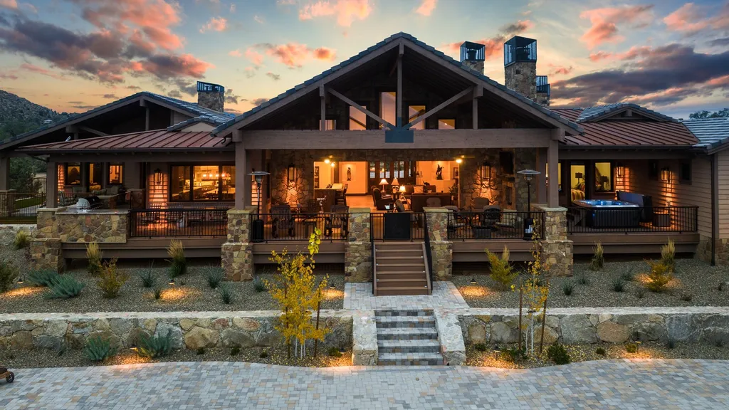 4971 West Three Forks Road Home in Prescott, Arizona. Explore the epitome of luxury living in this privately gated ranch compound with unobstructed views. This 4-bedroom, 5,555 sq.ft home features a 7-car garage, attached guest quarters, private pool with cabana, wet bar, and a 20 ft indoor-outdoor panoramic glass wall door.