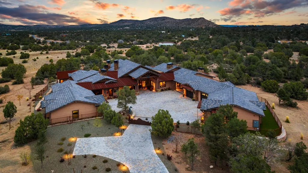 4971 West Three Forks Road Home in Prescott, Arizona. Explore the epitome of luxury living in this privately gated ranch compound with unobstructed views. This 4-bedroom, 5,555 sq.ft home features a 7-car garage, attached guest quarters, private pool with cabana, wet bar, and a 20 ft indoor-outdoor panoramic glass wall door.