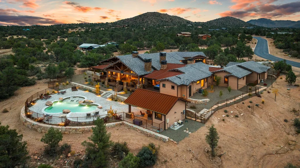 4971 West Three Forks Road Home in Prescott, Arizona. Explore the epitome of luxury living in this privately gated ranch compound with unobstructed views. This 4-bedroom, 5,555 sq.ft home features a 7-car garage, attached guest quarters, private pool with cabana, wet bar, and a 20 ft indoor-outdoor panoramic glass wall door.