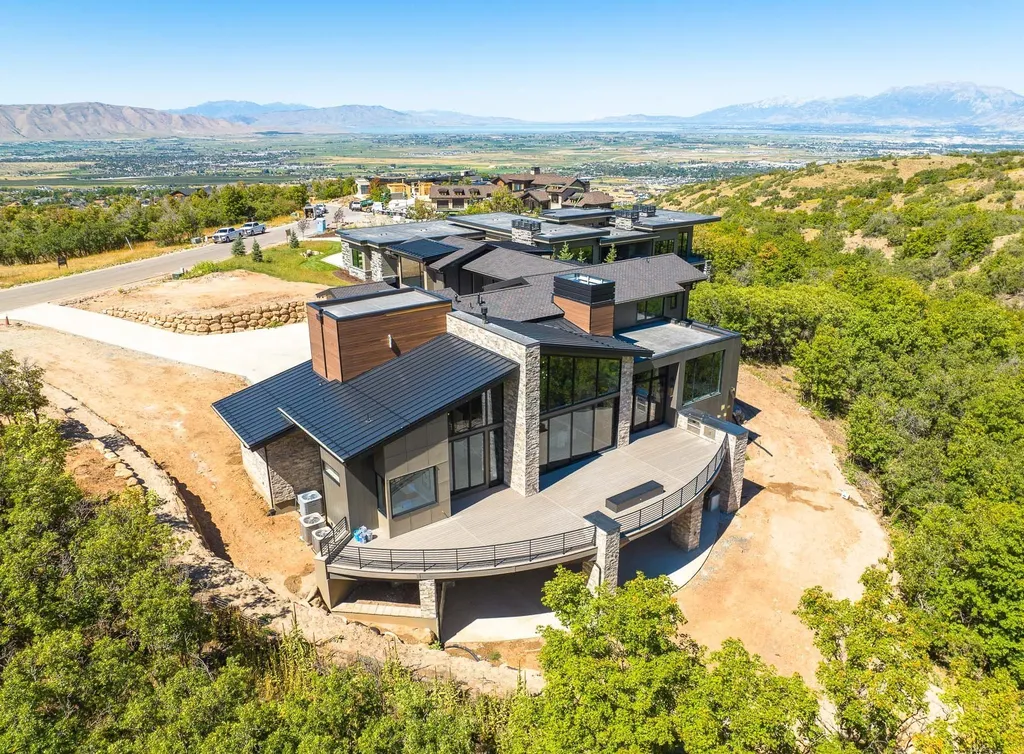 927 South Summit Creek Drive Home in Woodland Hills, Utah. Step into your custom dream home in Summit Creek, offering luxury living and unparalleled natural beauty. This magnificent residence, spanning 8,043 square feet on a .90-acre lot, presents stunning views of mountains and valleys. Floor-to-ceiling windows bathe the open-concept interior in natural light and provide uninterrupted scenic views. 
