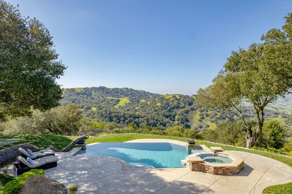 9767 Santos Ranch Road Home in Pleasanton, California. Experience the epitome of wine country living in this 4700+ SF luxury residence by Prodigy Real Estate. Boasting 4 bedrooms, 5 bathrooms, an office, and impeccable craftsmanship, this home offers a thoughtfully designed floor plan, soaring ceilings, and expansive windows to capture panoramic views. 
