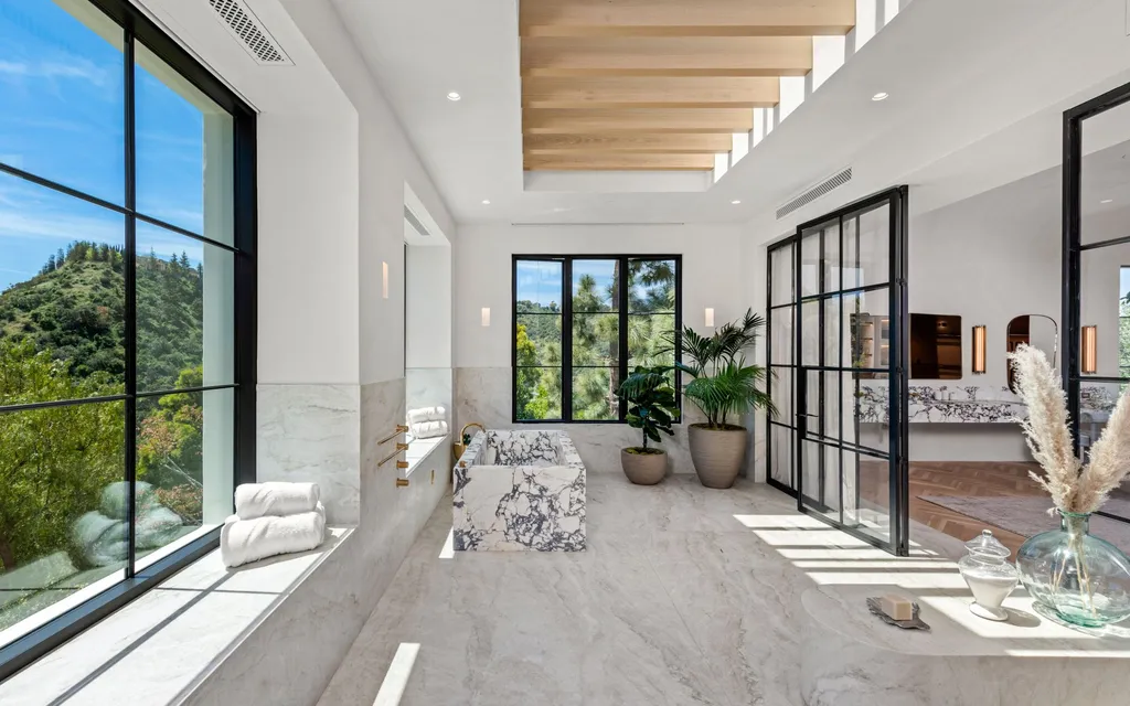 9904 Kip Drive Home in Beverly Hills, California. Enter the world of opulence and exclusivity with this celebrity compound behind gated privacy. Designed by KAA Associates, the 25,000 SF estate boasts 7 bedrooms, 13 bathrooms, lush gardens, and stunning canyon, city, and ocean views. 