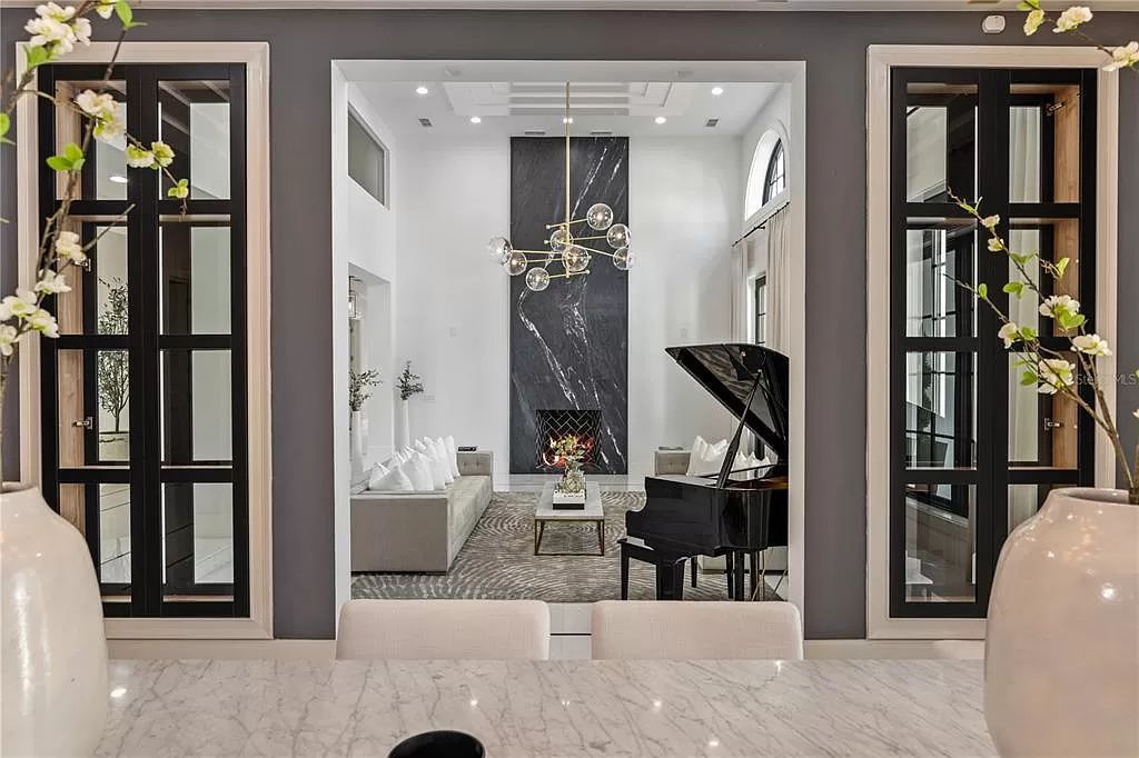 Discover Winter Park's epitome of luxury living in this architectural masterpiece by award-winning architect Larry Boerder. Just steps from Park Avenue's upscale boutiques and restaurants, this 2021-built estate boasts opulence at every turn.