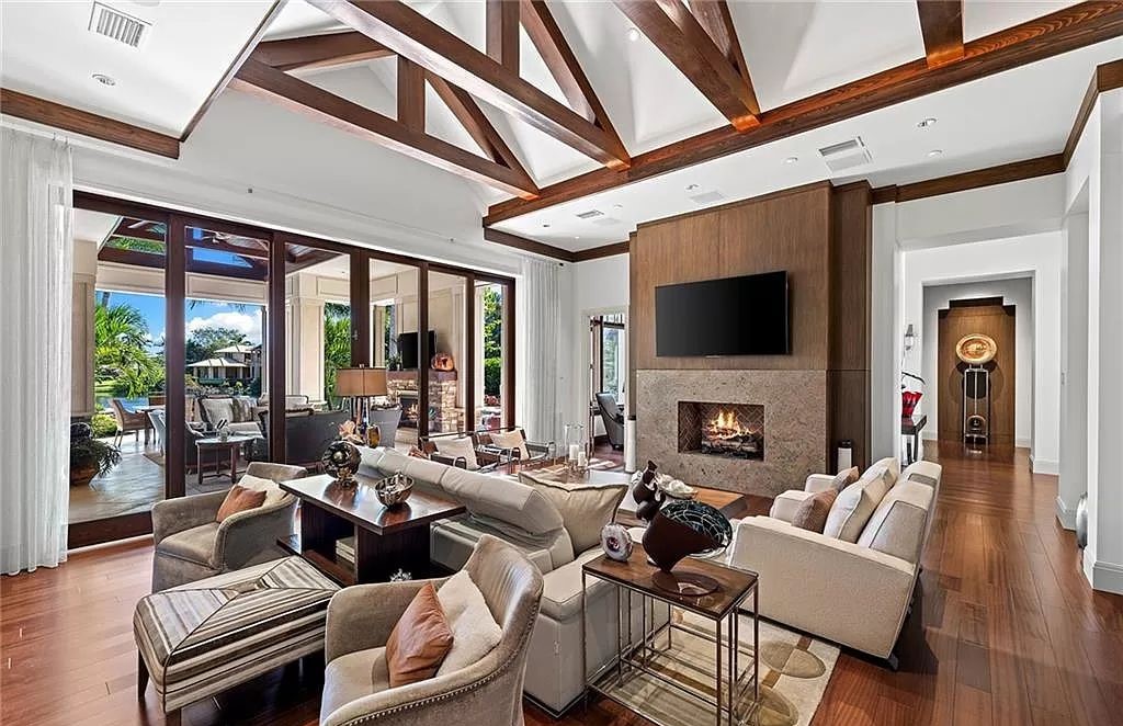 Discover the epitome of luxury living in the heart of Naples at 655 Bougainvillea Rd. This exquisite 7,660-square-foot lakefront estate, crafted by renowned architect John Cooney, boasts a seamless blend of warm tones and minimalist design.