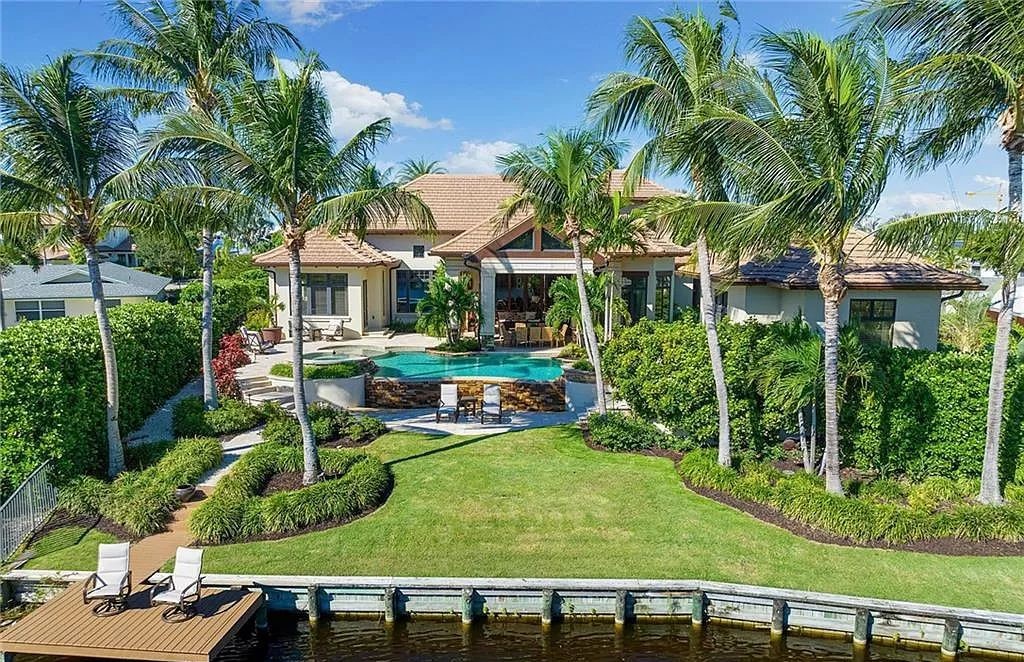 Discover the epitome of luxury living in the heart of Naples at 655 Bougainvillea Rd. This exquisite 7,660-square-foot lakefront estate, crafted by renowned architect John Cooney, boasts a seamless blend of warm tones and minimalist design.