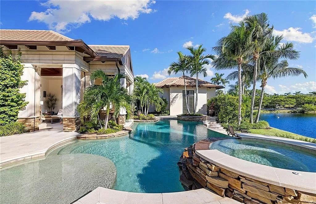 Discover the epitome of luxury living in the heart of Naples at 655 Bougainvillea Rd. This exquisite 7,660-square-foot lakefront estate, crafted by renowned architect John Cooney, boasts a seamless blend of warm tones and minimalist design.