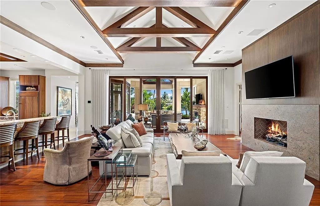 Discover the epitome of luxury living in the heart of Naples at 655 Bougainvillea Rd. This exquisite 7,660-square-foot lakefront estate, crafted by renowned architect John Cooney, boasts a seamless blend of warm tones and minimalist design.