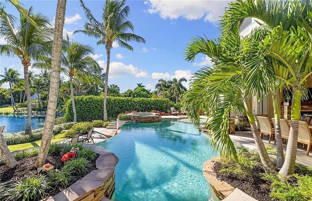 Discover the epitome of luxury living in the heart of Naples at 655 Bougainvillea Rd. This exquisite 7,660-square-foot lakefront estate, crafted by renowned architect John Cooney, boasts a seamless blend of warm tones and minimalist design.