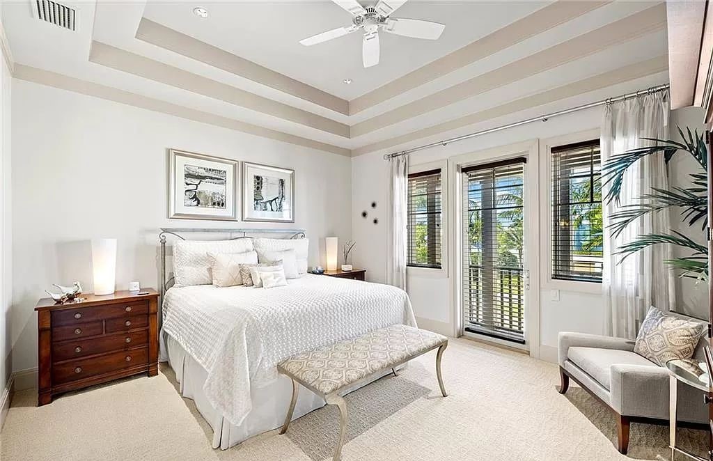 Discover the epitome of luxury living in the heart of Naples at 655 Bougainvillea Rd. This exquisite 7,660-square-foot lakefront estate, crafted by renowned architect John Cooney, boasts a seamless blend of warm tones and minimalist design.