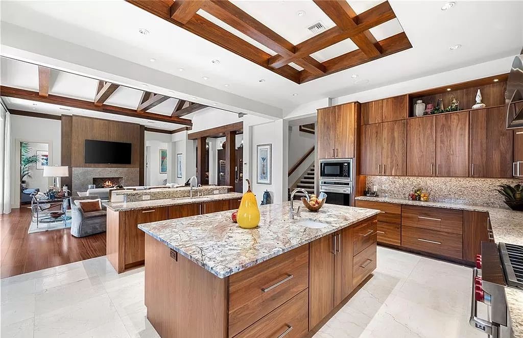 Discover the epitome of luxury living in the heart of Naples at 655 Bougainvillea Rd. This exquisite 7,660-square-foot lakefront estate, crafted by renowned architect John Cooney, boasts a seamless blend of warm tones and minimalist design.