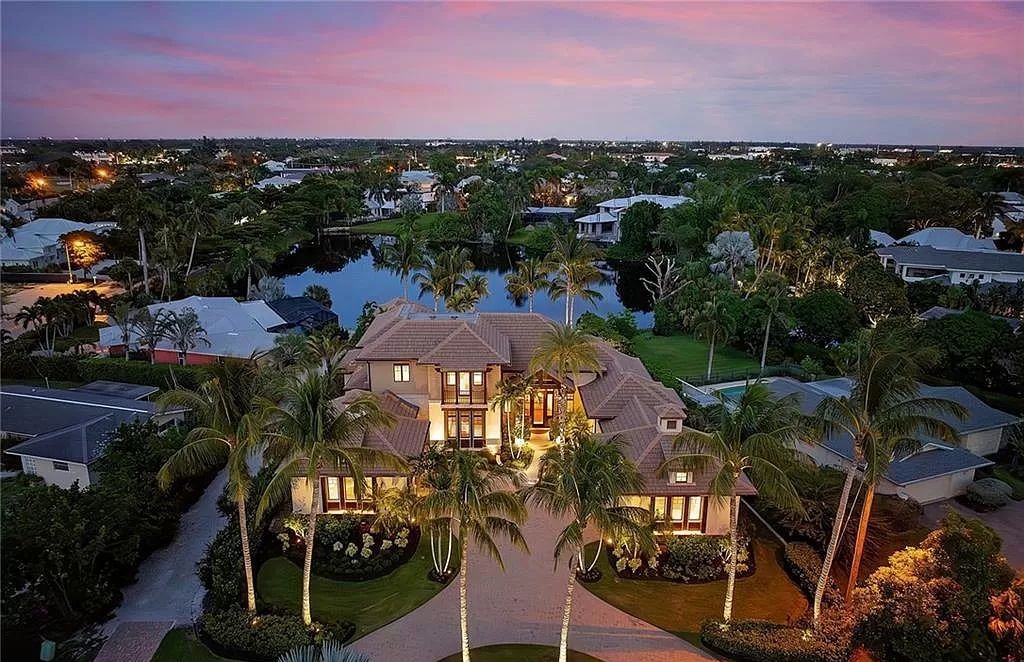 Discover the epitome of luxury living in the heart of Naples at 655 Bougainvillea Rd. This exquisite 7,660-square-foot lakefront estate, crafted by renowned architect John Cooney, boasts a seamless blend of warm tones and minimalist design.