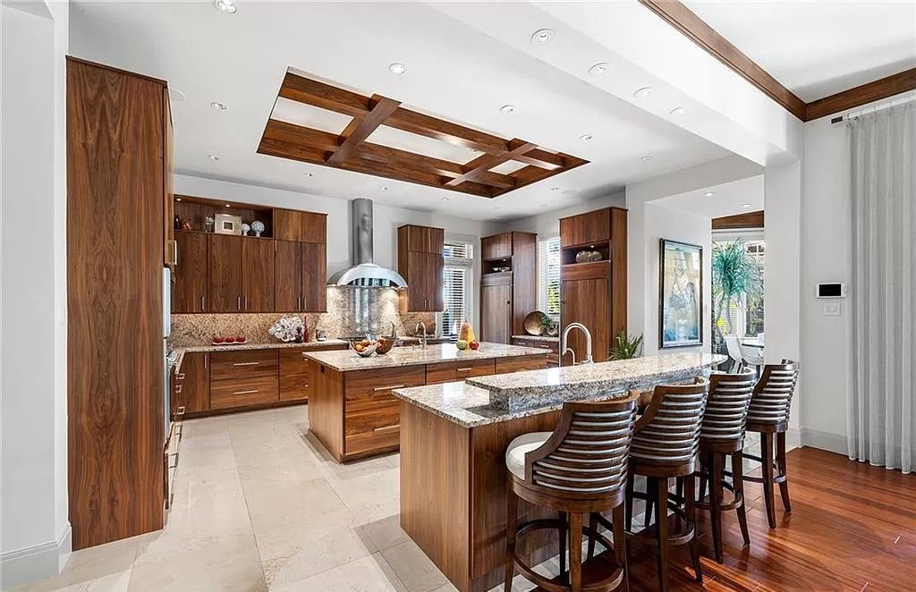 Discover the epitome of luxury living in the heart of Naples at 655 Bougainvillea Rd. This exquisite 7,660-square-foot lakefront estate, crafted by renowned architect John Cooney, boasts a seamless blend of warm tones and minimalist design.